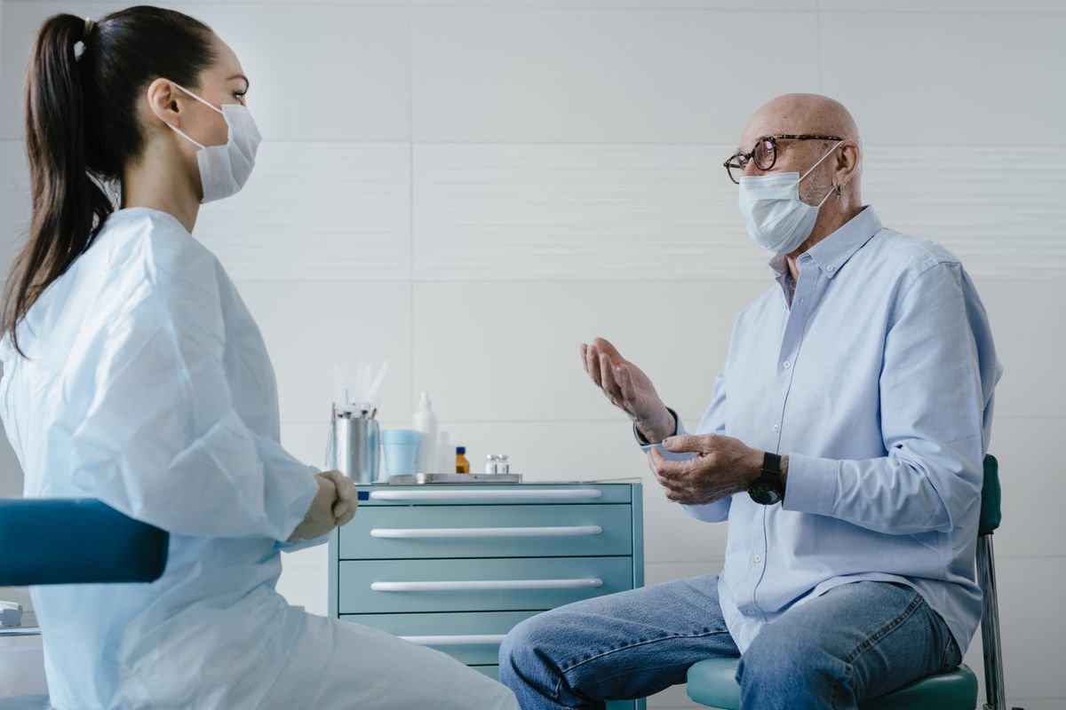 Paciente adulto mayor conversando con su médico en consulta clínica