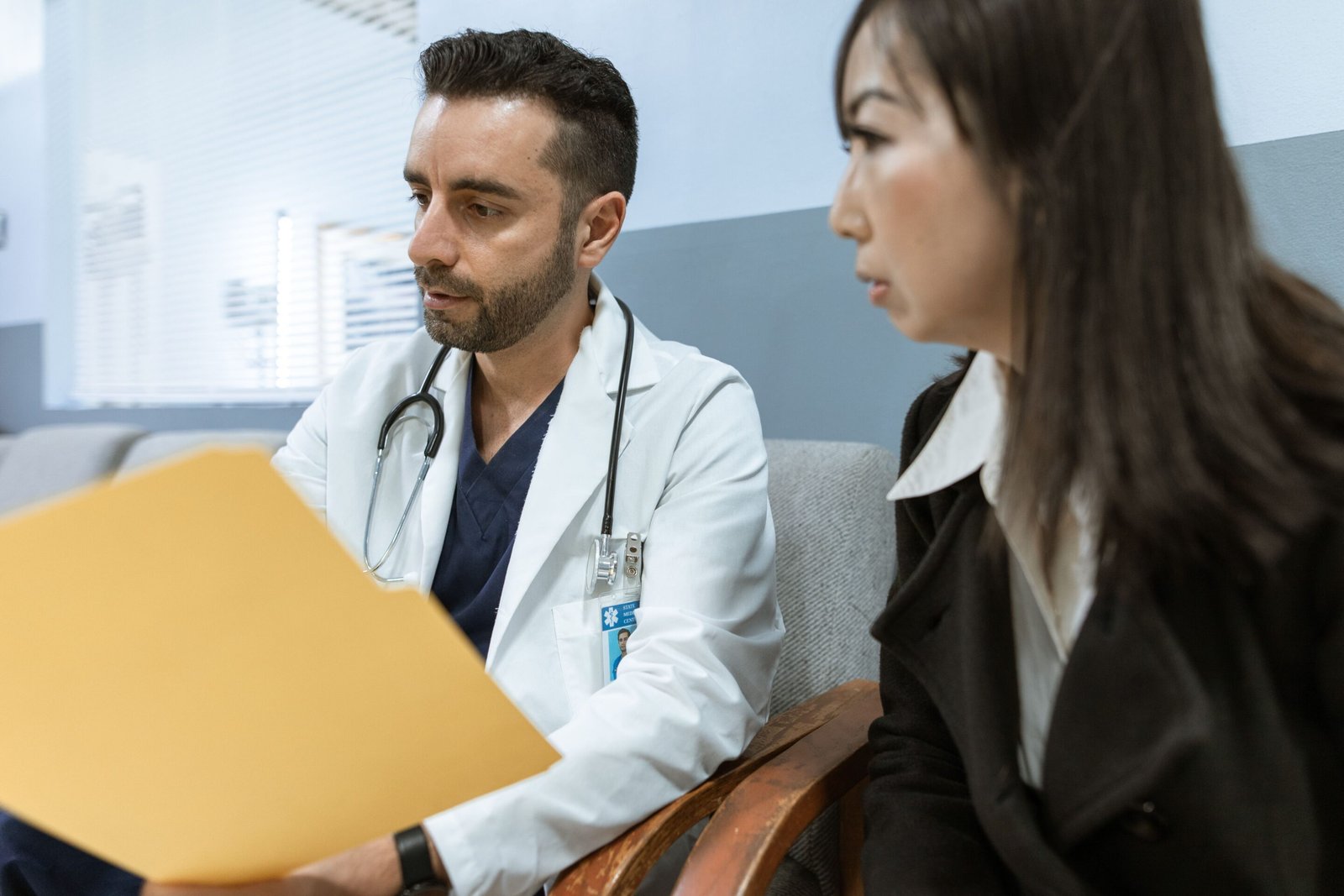 Profesional de la salud conversando con un paciente en consultorio