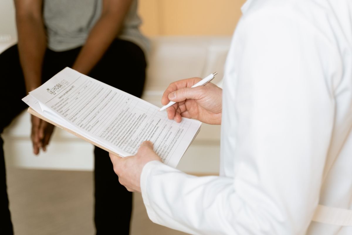 Profesional de salud revisando un formulario médico durante una consulta